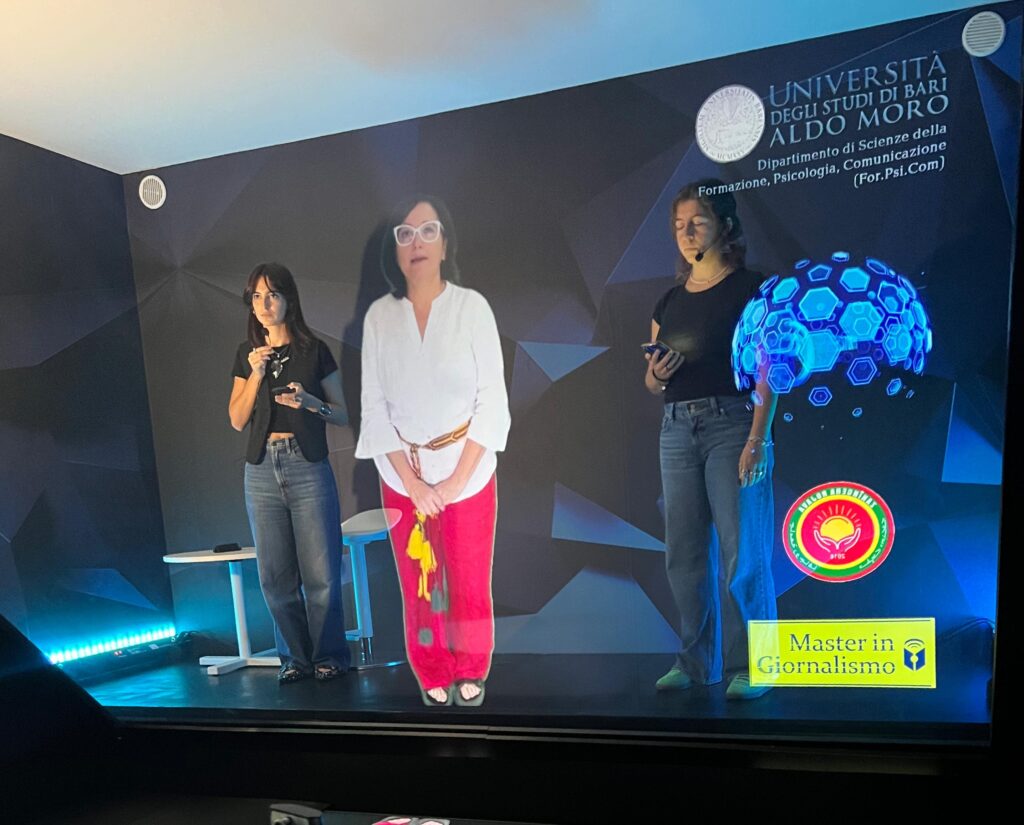 L'ologramma della giornalista e ricercatrice Marilù Mastrogiovanni, collegata dall'Università del Rojava, tra Maria Antonietta Mastropasqua e Dalila Scagliusi, praticanti del Master in giornalismo, in presenza presso l'Università di Bari. L'esperimento è perfettamente riuscito